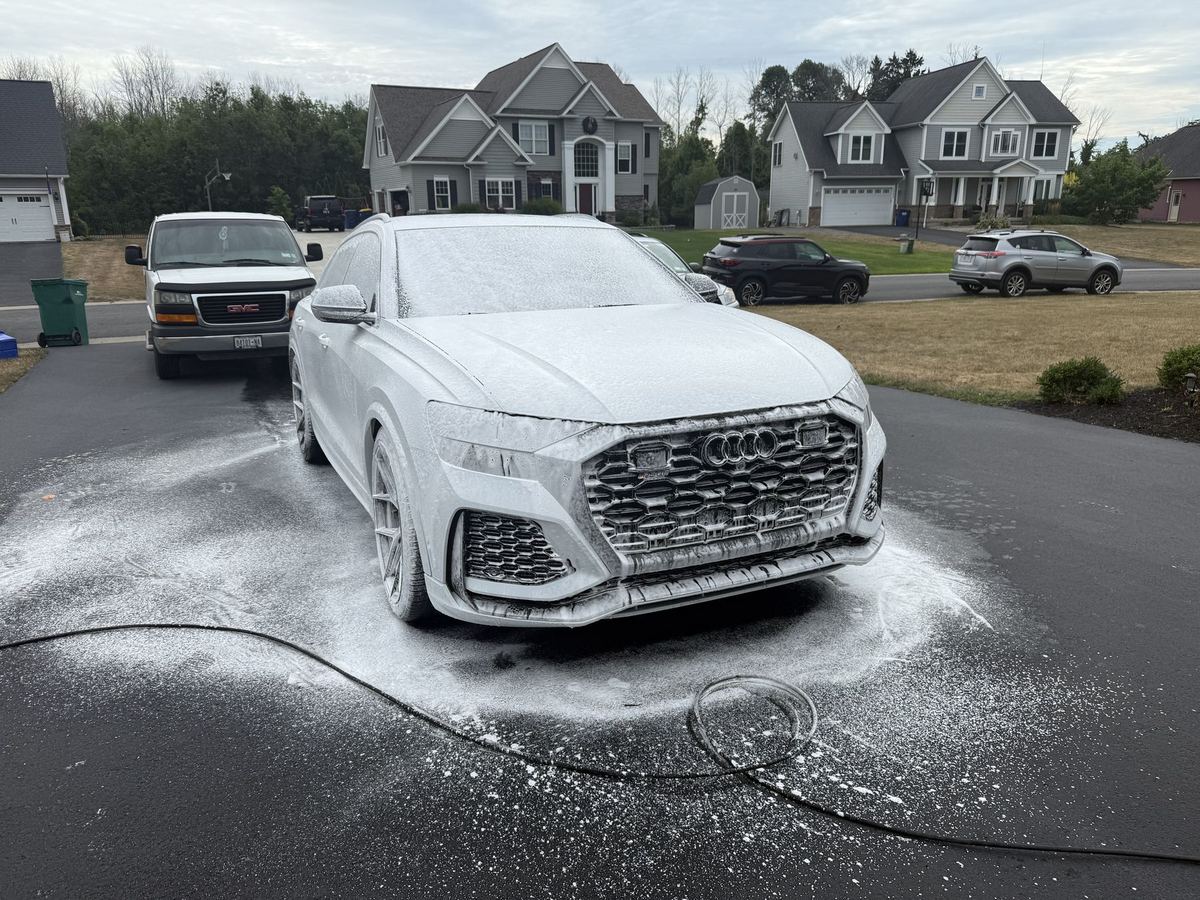 An Audi RS Q8 covered in a thick layer of snow foam during a mobile car detail