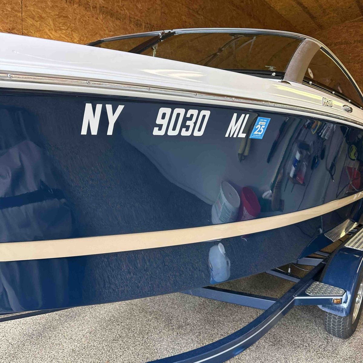 Polished navy hull of a Four Winns bowrider after a marine detail