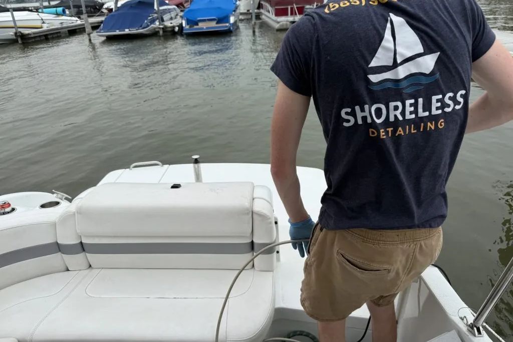 A Shoreless Detailing technician working on boat upholstery at a Finger Lakes marina